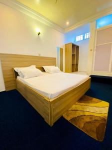 a bedroom with a large bed with white sheets at Eliass Palace in Cotonou