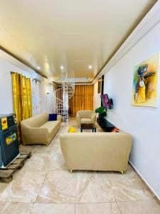 a living room with two couches and a tv at Eliass Palace in Cotonou