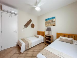 a bedroom with two beds and a ceiling fan at Riviera | Aconchegante e Charmoso - Enxoval Compl in Riviera de São Lourenço +84 photos