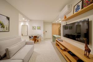 a living room with a couch and a giraffe on the wall at Mingus Residencial Flipchave MIN000 in Joinville