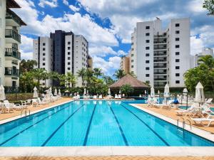 a swimming pool with chaise lounges and chairs at Riviera | Aconchegante e Charmoso - Enxoval Compl in Riviera de São Lourenço