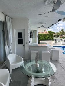 a living room with a table and chairs and a pool at Lux 4 bedroom home on lake with pool! in Coral Springs +40 photos