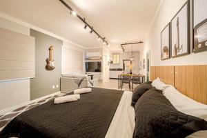 a bedroom with a large bed and a living room at Mingus Residencial Flipchave MIN000 in Joinville