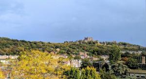 un castillo en la cima de una colina con árboles en Historic Dover Stay with Stunning Castle View, en Dover 3 fotos más