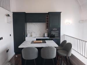 una cocina con armarios negros y una mesa con sillas en Historic Dover Stay with Stunning Castle View, en Dover