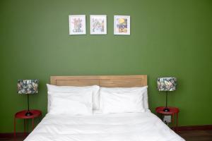 a bedroom with green walls and a bed with white pillows at The Diplomat Studio by Cape Living in Cape Town
