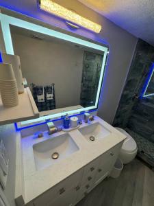 a bathroom with a white sink and a mirror at BEACHFRONT OCEANVIEW BALCONY GAMES POOL 75 TV in Cape Canaveral +36 photos