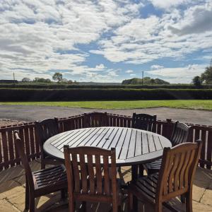 a wooden table with two chairs and a table and a table and chairs at Lodge Barns in Fiskerton