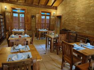 a dining room with wooden tables and chairs at Pousada dos Pássaros in Santo Antônio do Pinhal