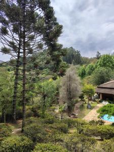 a view of a garden with a swimming pool at Pousada dos Pássaros in Santo Antônio do Pinhal
