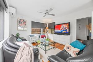 Relax Unwind in Berwick Multiple Retreat Walk to shops في بيرويك: غرفة معيشة مع أرائك وتلفزيون بشاشة مسطحة