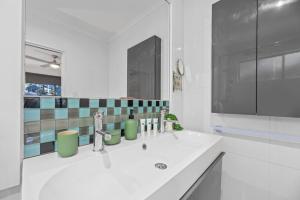 Relax Unwind in Berwick Multiple Retreat Walk to shops في بيرويك: حمام أبيض مع حوض ومرآة +11 صورة