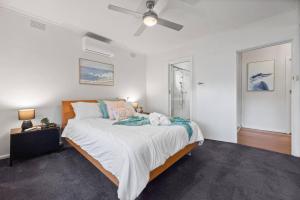 Relax Unwind in Berwick Multiple Retreat Walk to shops في بيرويك: غرفة نوم بسرير كبير مع مروحة سقف