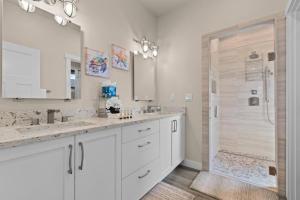 un baño con dos lavabos y una ducha en Ainamalu, en Waikoloa 42 fotos más