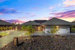 Una casa al atardecer con luces en la entrada. en Ainamalu, en Waikoloa
