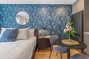 a bedroom with a bed and a table with a mirror at Chick and Cozy Haven near Banff with Hot tub and Pool in Canmore