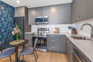 a kitchen with gray cabinets and a table with a vase of flowers at Chick and Cozy Haven near Banff with Hot tub and Pool in Canmore
