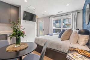 a bedroom with a large bed and a table with a tableablish at Chick and Cozy Haven near Banff with Hot tub and Pool in Canmore +11 photos