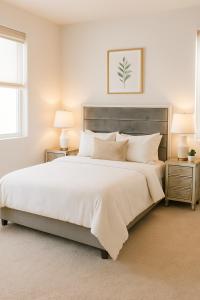 a bedroom with a large white bed with two night stands at Modern Private Room with Private Bath in Manteca