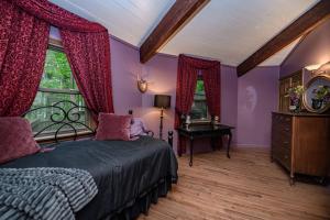 una camera da letto con pareti viola, un letto e una finestra di The DodeCanopy a Columbia