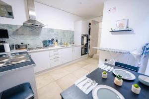 卡迪夫Explore Cardiff - Stylish Studio Apartment Near City Centre的配有白色橱柜和蓝色台面的大厨房 更多7张照片
