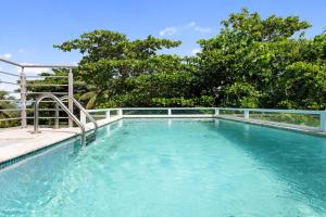 une piscine d'eau bleue et une clôture dans l'établissement Casa Angelica Apt 203 steps to Sandy Beach, à Centro Puntas
