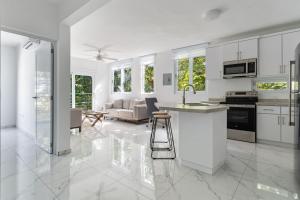 Il comprend une cuisine et un salon avec des placards blancs. dans l'établissement Casa Angelica Apt 203 steps to Sandy Beach, à Centro Puntas