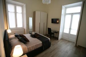 1 Schlafzimmer mit einem Bett, 2 Fenstern und einem Schreibtisch in der Unterkunft B&B Il Ritratto in Salerno