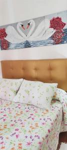 a bedroom with a bed with floral pillows at Apartamentos de Salvadora I in El Bosque