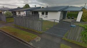 a fence in front of a house with houses at McKerrow St - 2 in Te Anau