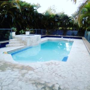 a swimming pool with blue water and palm trees at Hacienda El Palmar D in Vega Baja