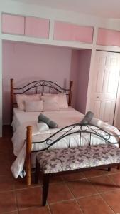 a bedroom with two beds and a bench at Hacienda El Palmar D in Vega Baja