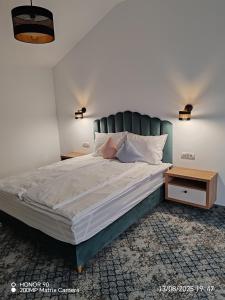 een slaapkamer met een groot bed met een blauw hoofdeinde bij Emirage Pool & Spa in Şimon