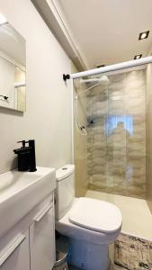 a bathroom with a toilet and a glass shower at Apartamento Guarujá, com sacada vista mar! Pé na areia, Lindo! in Guarujá +36 photos