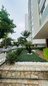a garden in front of a building at Apartamento Guarujá, com sacada vista mar! Pé na areia, Lindo! in Guarujá