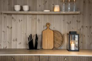 Ein hölzernes Schneidebrett steht mit einer Kerze auf einem Regal. in der Unterkunft Spacious & luxury Skilodge in Trysil in Trysil