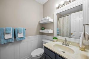 a bathroom with a sink and a toilet and a mirror at 3 Bedroom Home with King Bed, Fenced Yard & Pool Table in New Bern +22 photos