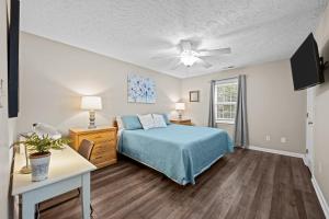 a bedroom with a bed and a ceiling fan at 3 Bedroom Home with King Bed, Fenced Yard & Pool Table in New Bern