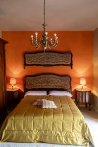 a bedroom with a large bed with an orange wall at CA'du LIN - Jacuzzi e Piscina in Cisterna dʼAsti +228 photos