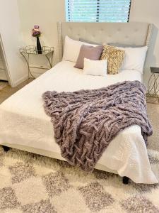 1 dormitorio con 1 cama blanca grande con manta en Legacy Lodge, en Denison