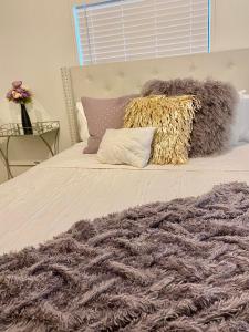 Una cama con una manta gris y almohadas encima. en Legacy Lodge, en Denison