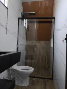 サン・ロケ・デ・ミナスにあるChalés JHのトイレとガラスのシャワー付きのバスルーム
