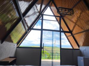 a room with a large window in a barn at Chalés JH in São Roque de Minas