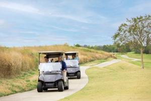 a group of people riding in a golf cart at Palmer Room at The Inn, Occano Arnold Palmer Golf  +21 photos