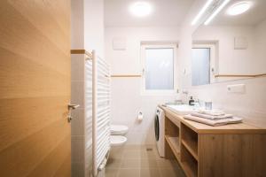 ein Badezimmer mit Waschbecken, Toilette und Spiegel in der Unterkunft dolomites view apartment in Oberrasen + 18 Fotos