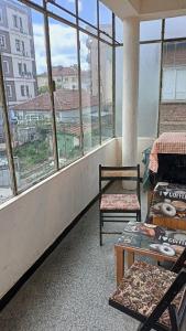 カザンラクにあるАпартамент за гости Казанлъкの椅子2脚とテーブル1台と窓のある部屋