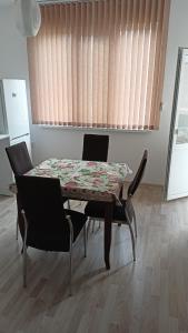 カザンラクにあるАпартамент за гости Казанлъкのダイニングルームテーブル(椅子2脚、テーブル1台付)、窓が備わります。