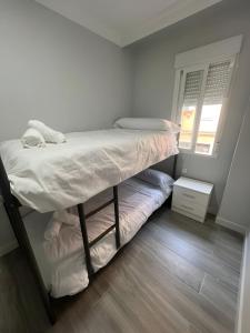 a small bedroom with a bunk bed and a window at Grey House in Huelva