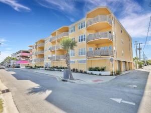 タイビーアイランドにあるRelax-Unwind-Enjoyの通りにヤシの木がある黄色いアパート