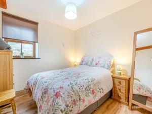 a bedroom with a bed and a mirror at The Cottage - Uk45459 in Loftus +8 photos